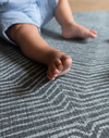 Little feet are cushioned the cushy play mat by Totter and Tumble with a modern monochrome design to complement nursery decor