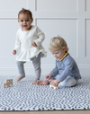 Toddlers are kept safe on the ergo foam play mat made from non toxic materials and thickly padded