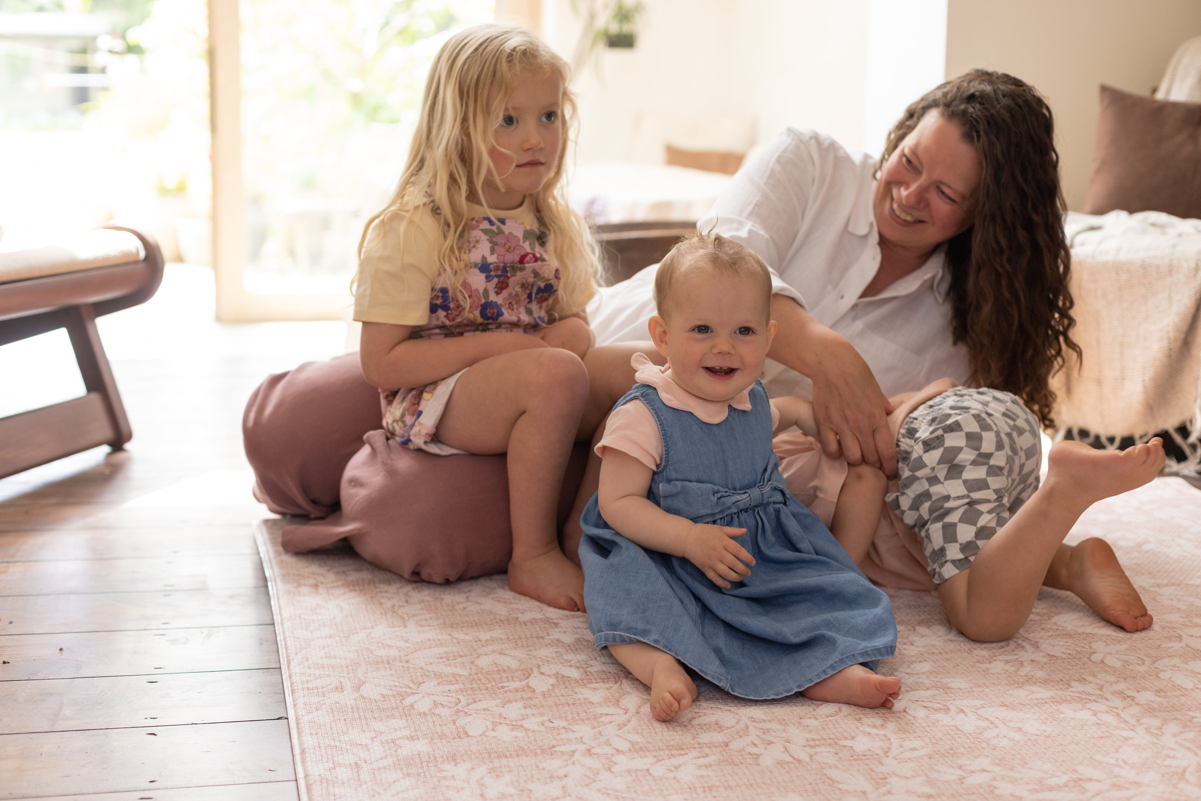 Family floor time on pink foam play mat by totter and tumble