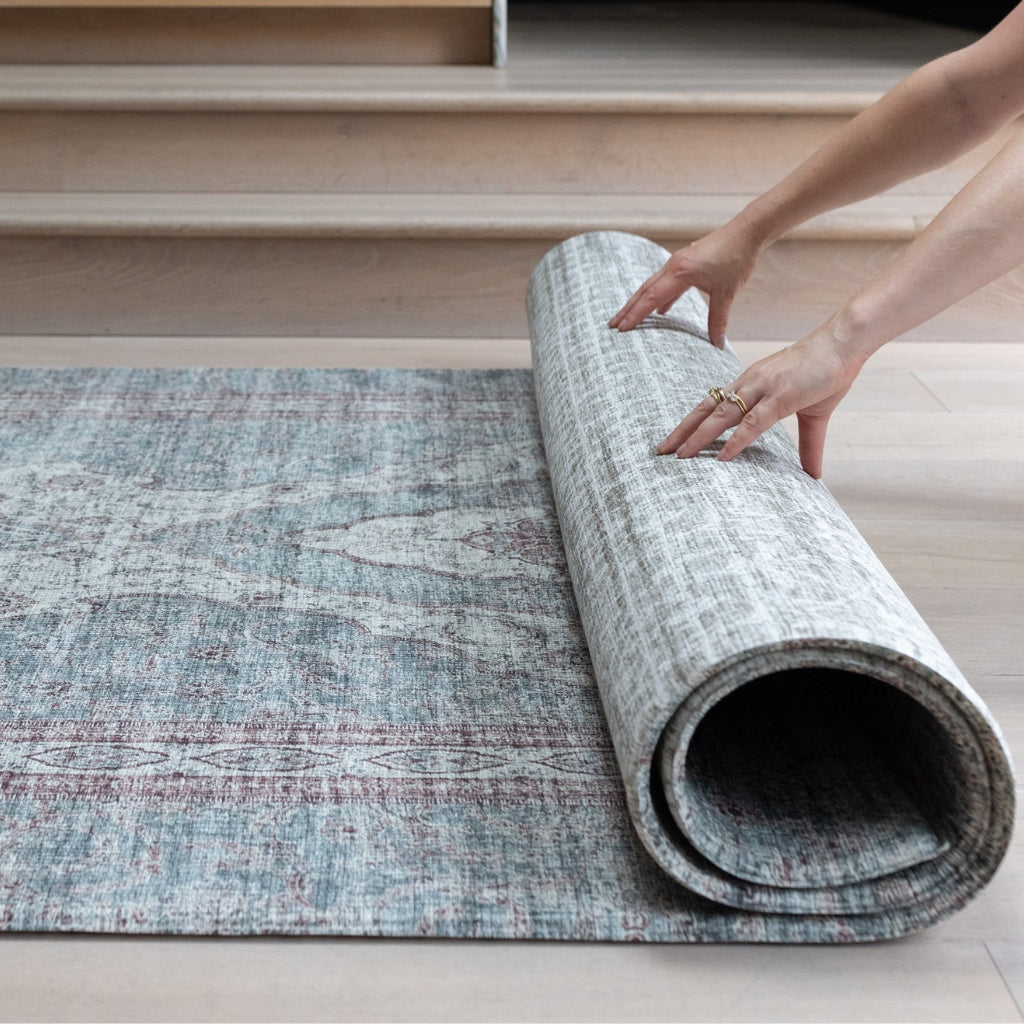 A rolled up play mat in extra large size. Showing a Persian rug design on one side and a timeworn textile style on the reverse.