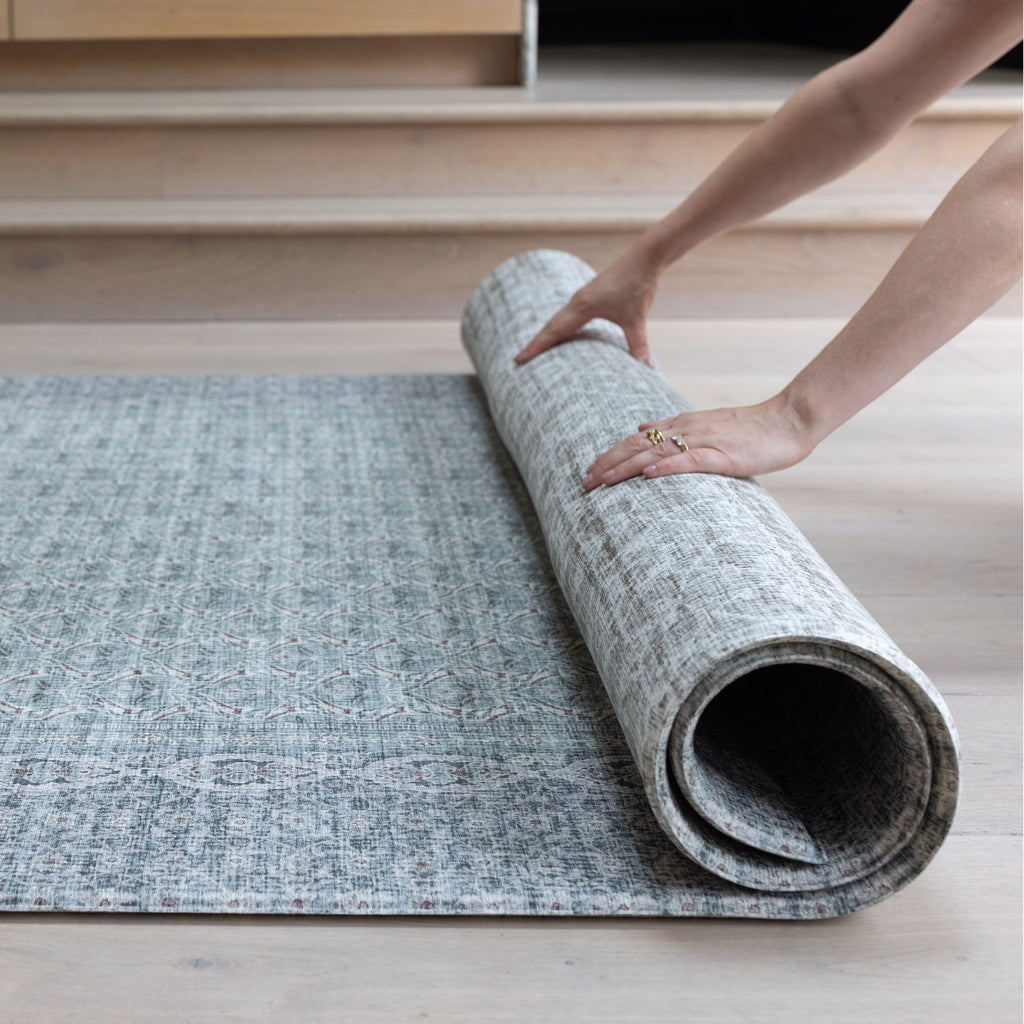 A rolled playmat featuring a delicate rug-like pattern on both sides