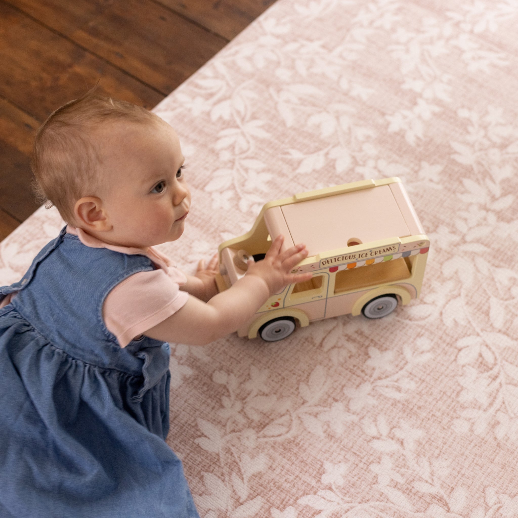 Baby playing on a non toxic pink floral memory foam play mat from totter and tumble