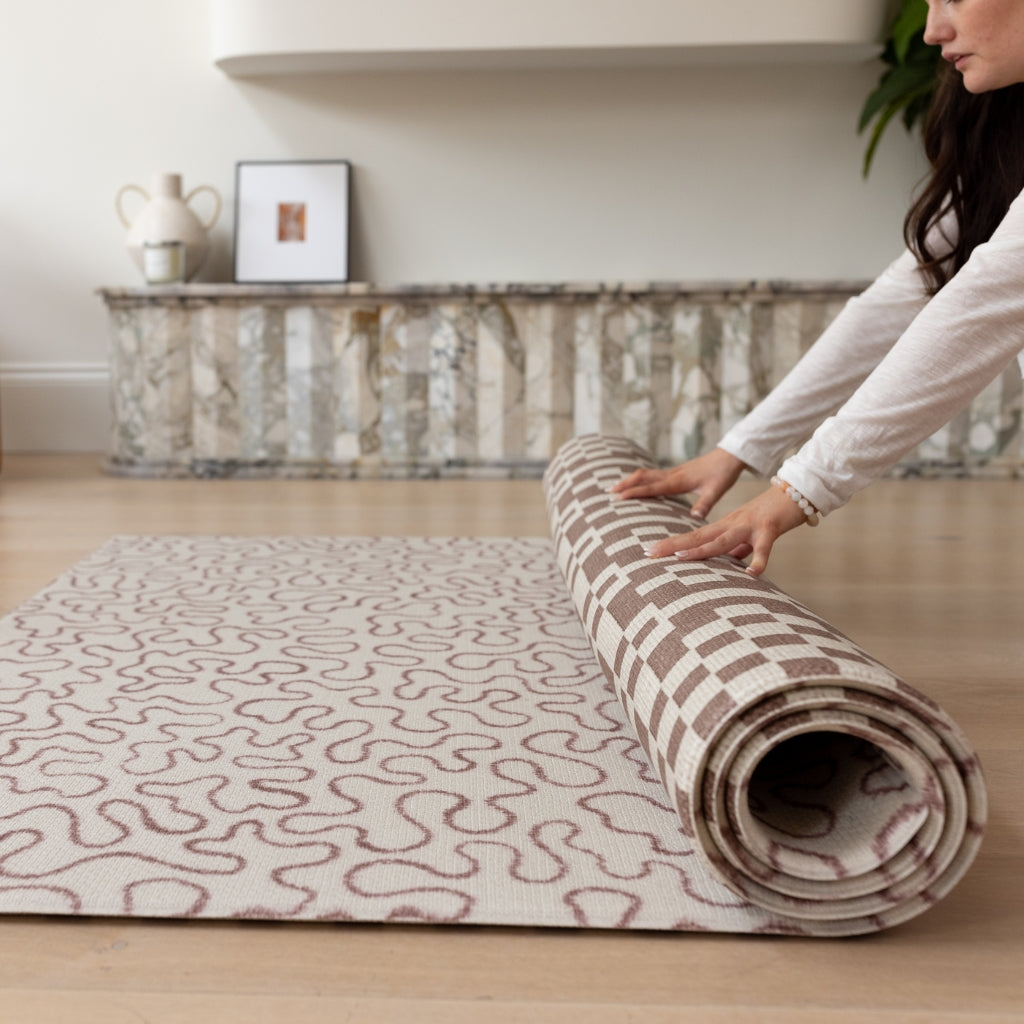 Unrolling a slate and sand play mat for a crawling baby