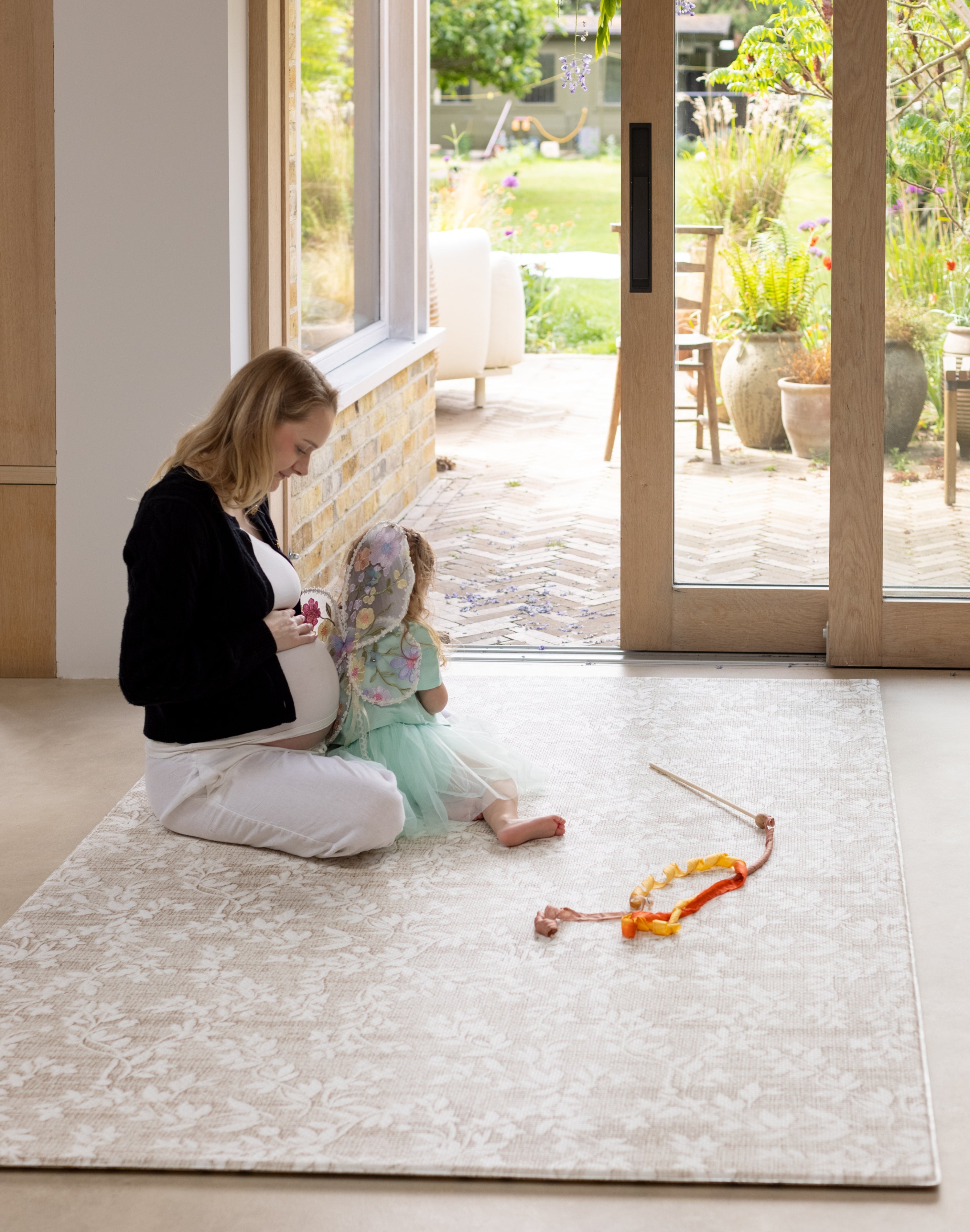 Woman and child playing on a rug-like comfortable floral play mat 