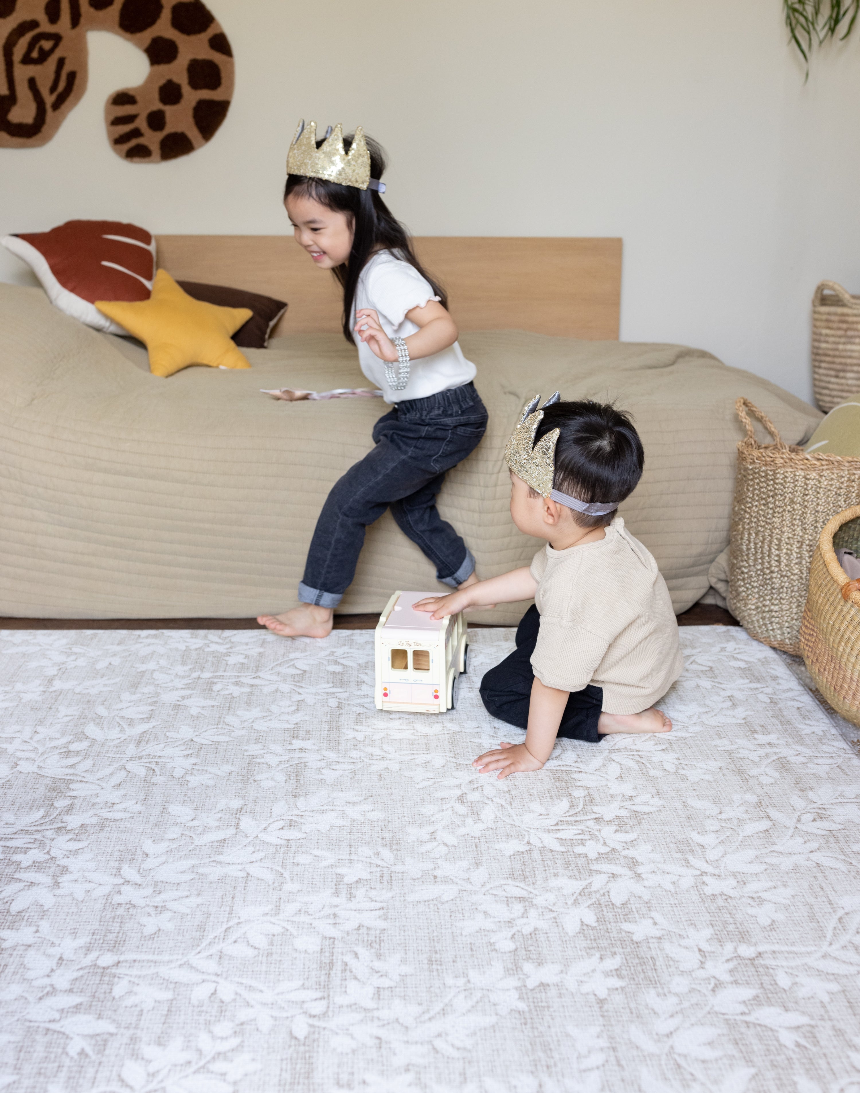 Two children playing on a large floral play mat from totter and tumble