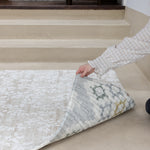person showing two sides of a thick memory foam reversible play mat with floral and geometric designs