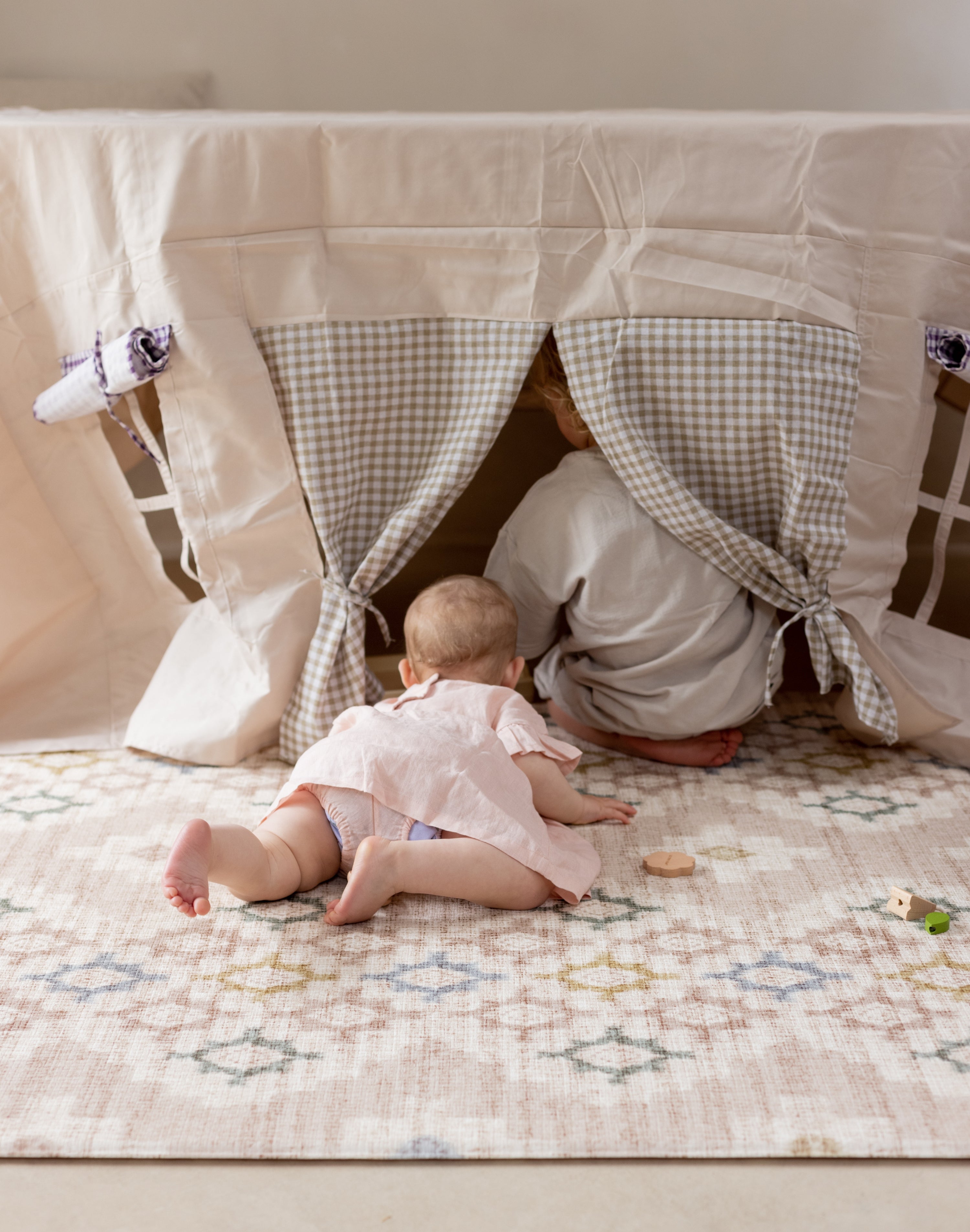 Children playing on a thick soft geometric pink play mat
