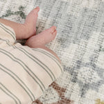 Close-up of a baby's feet on a patterned safe comfortable play mat