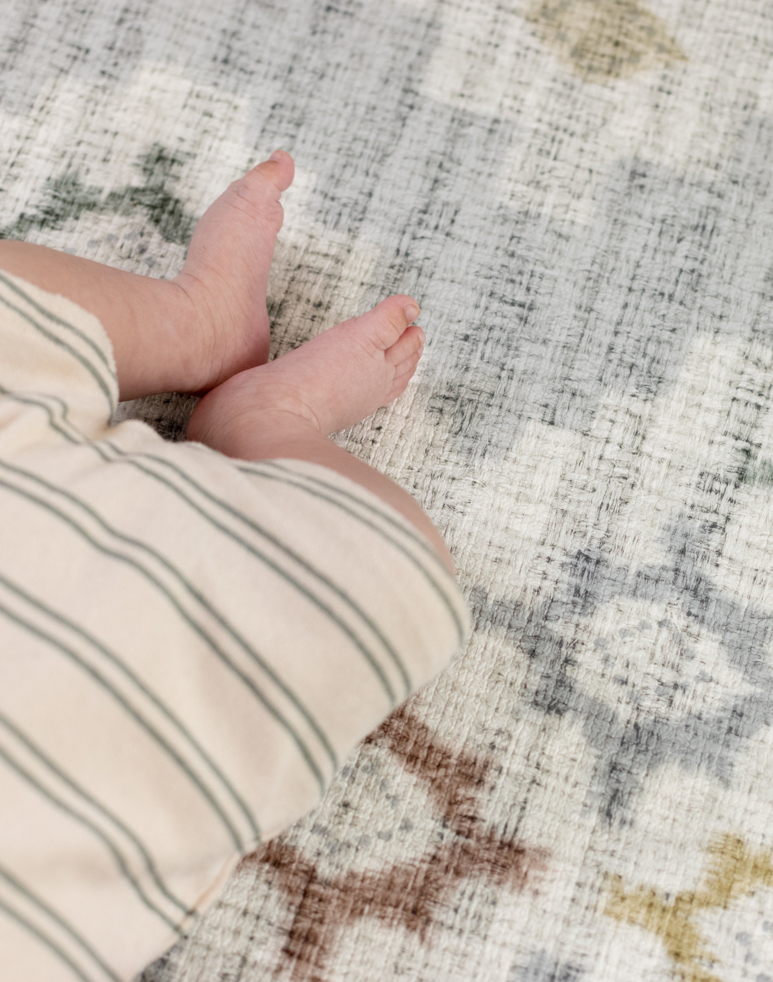Close-up of a baby's feet on a patterned safe comfortable play mat