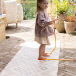 Child play outside on a comfortable easy to clean, wipeable totter and tumble play mat