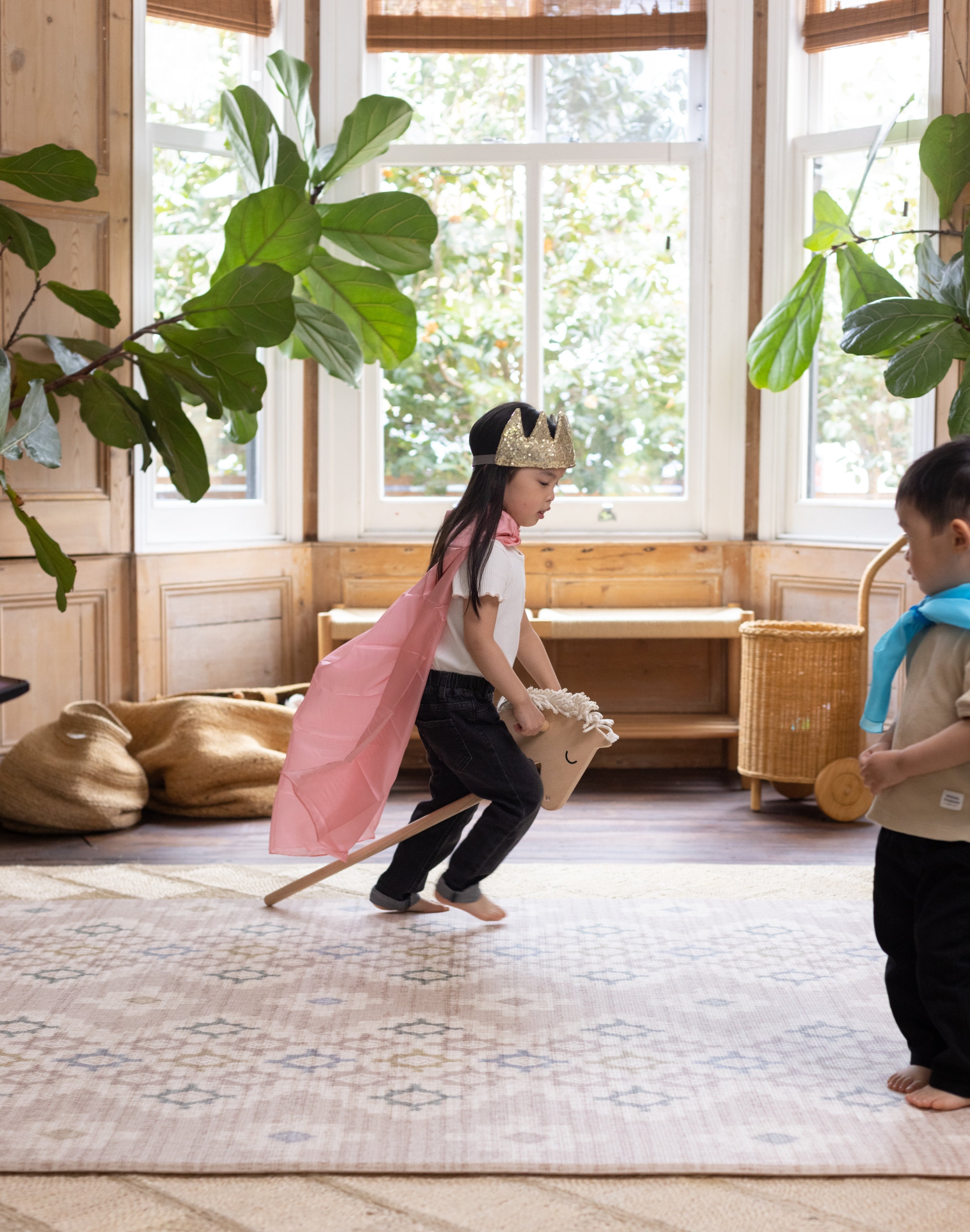 child playing on a large patterned play mat in a living room