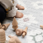 Wooden toys on a baby safe geometric patterned play mat
