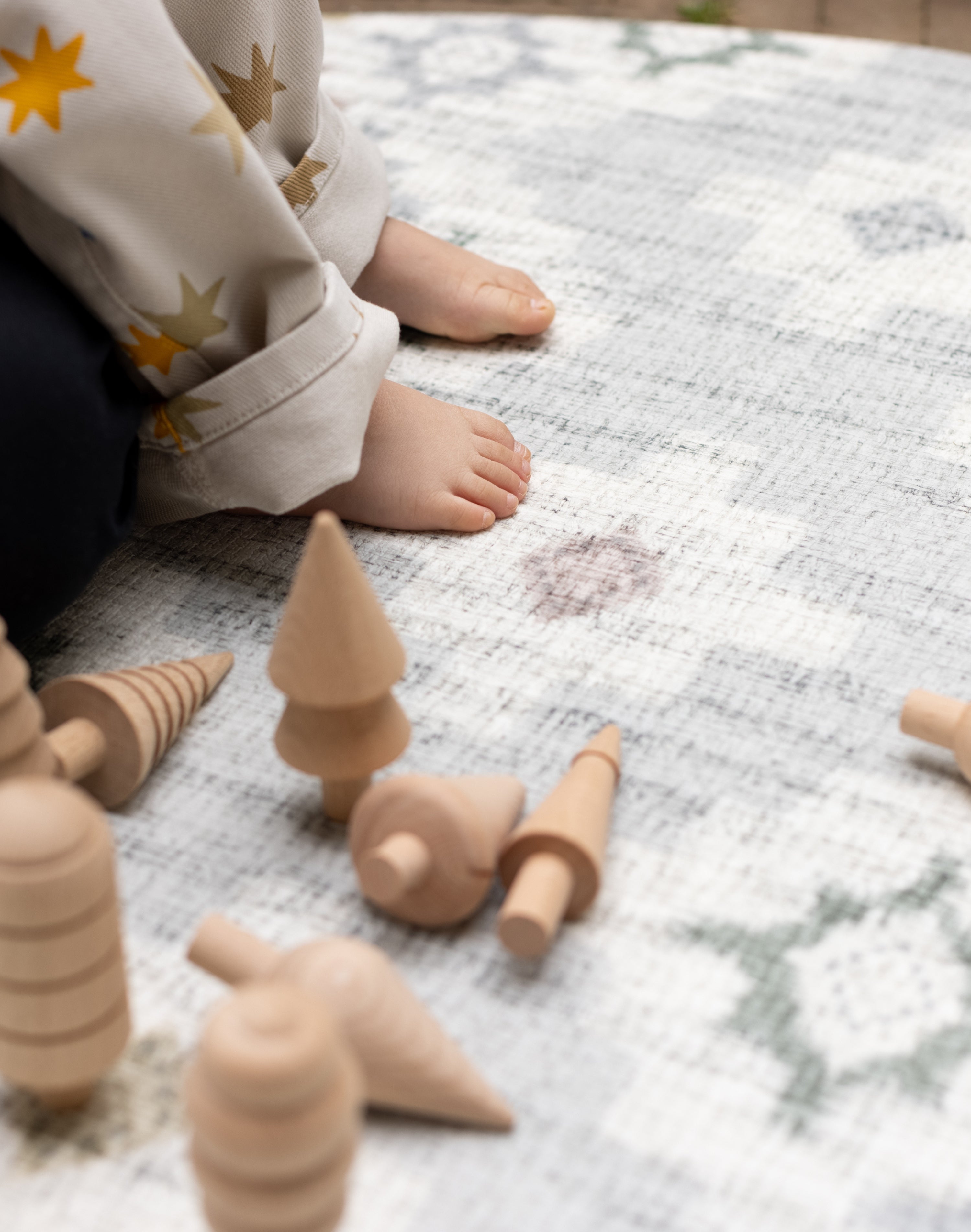 Wooden toys on a baby safe geometric patterned play mat