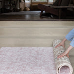 Person rolling out a patterned rug-like play mat from totter and tumble