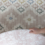 person showing two sides of a reversible round play mat