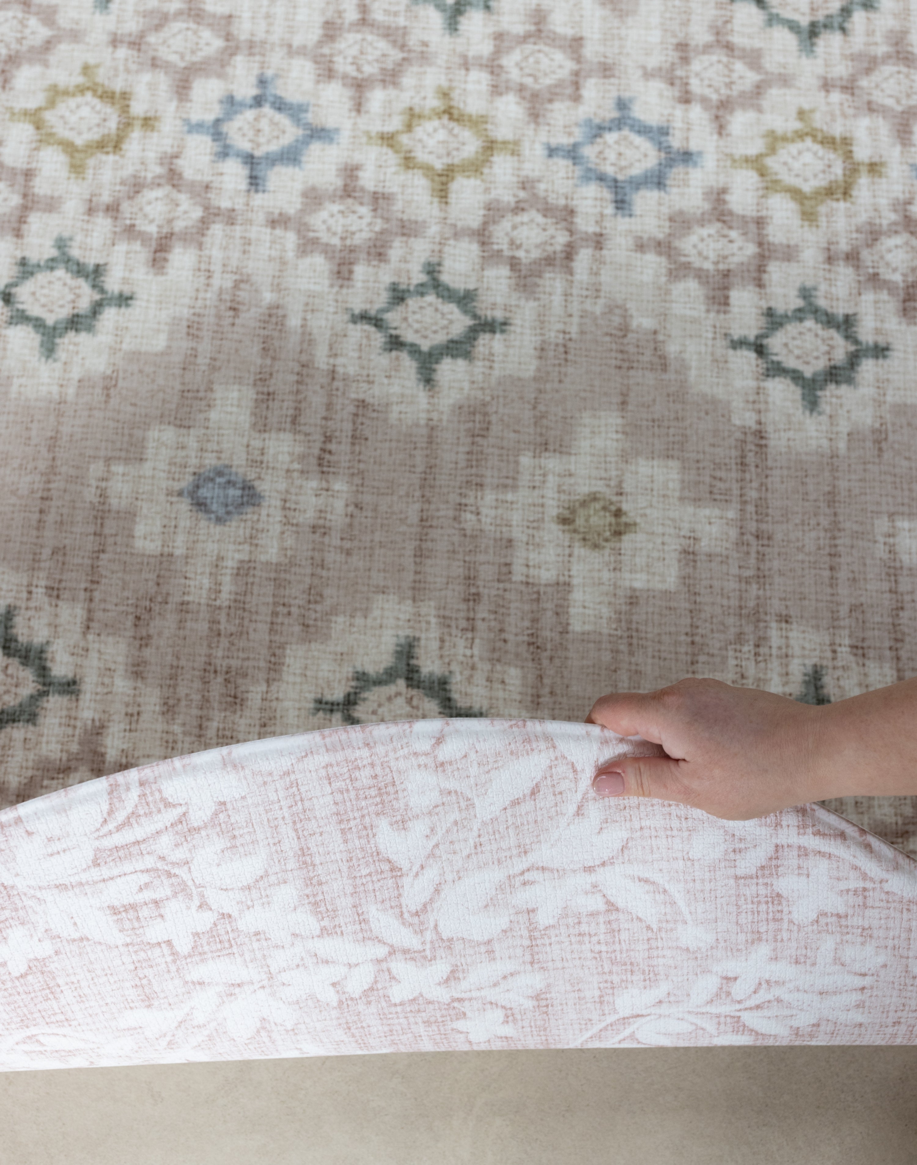 person showing two sides of a reversible round play mat