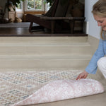 person showing two sides of a reversible totter and tumble play mat