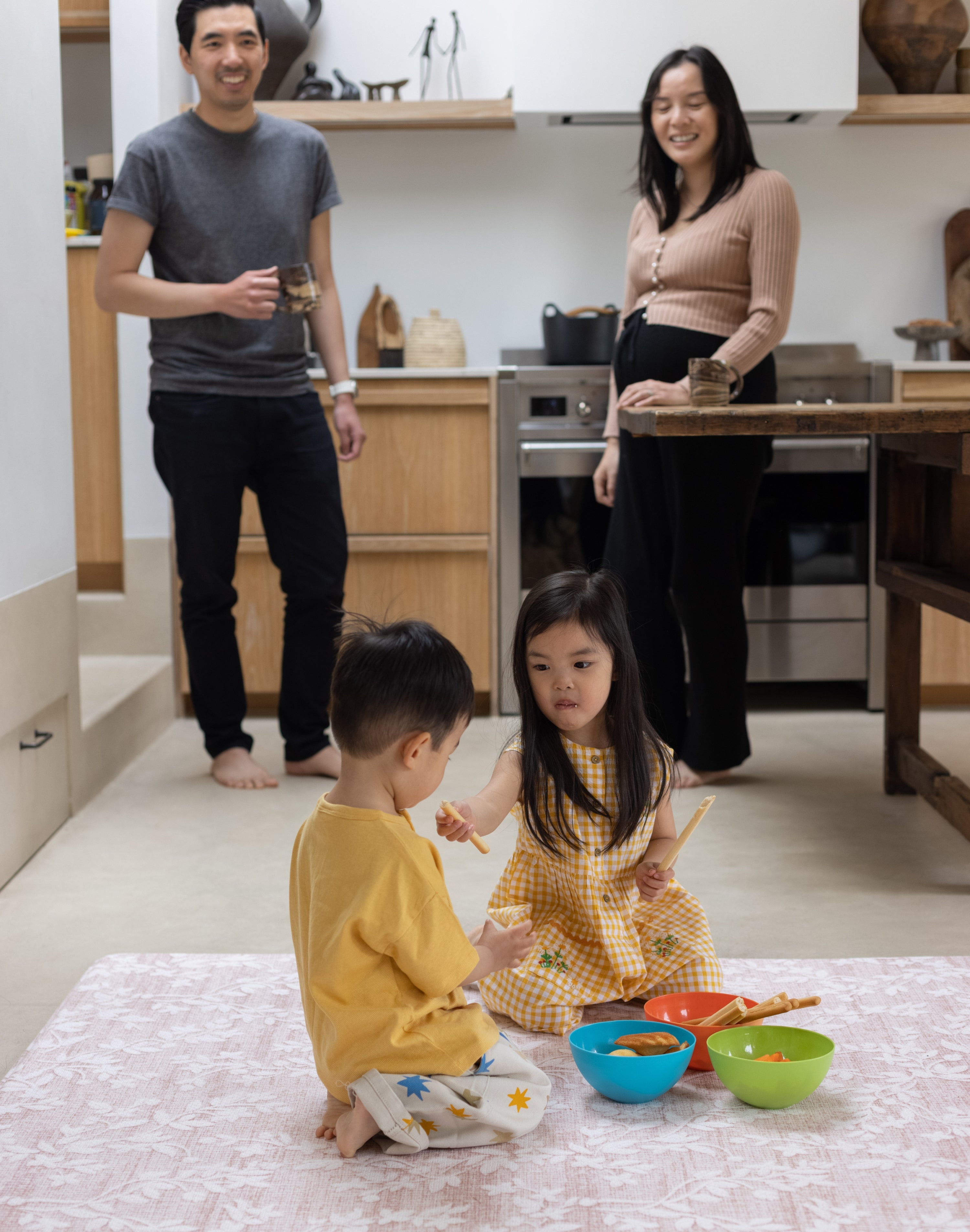 Family in the kitchen with a totter and tumble aster play mat