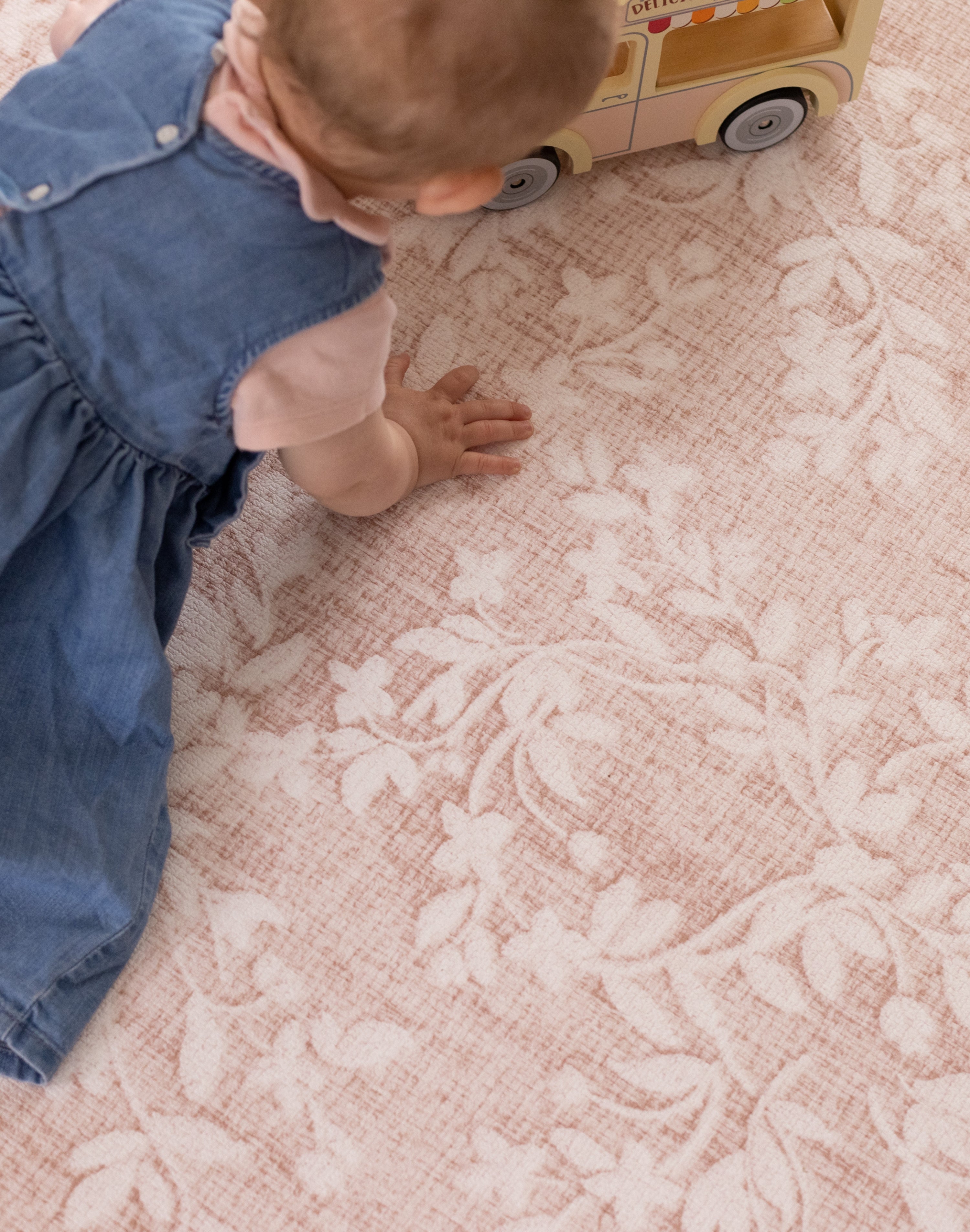 Close-up of the aster pink floral non-toxic play mat