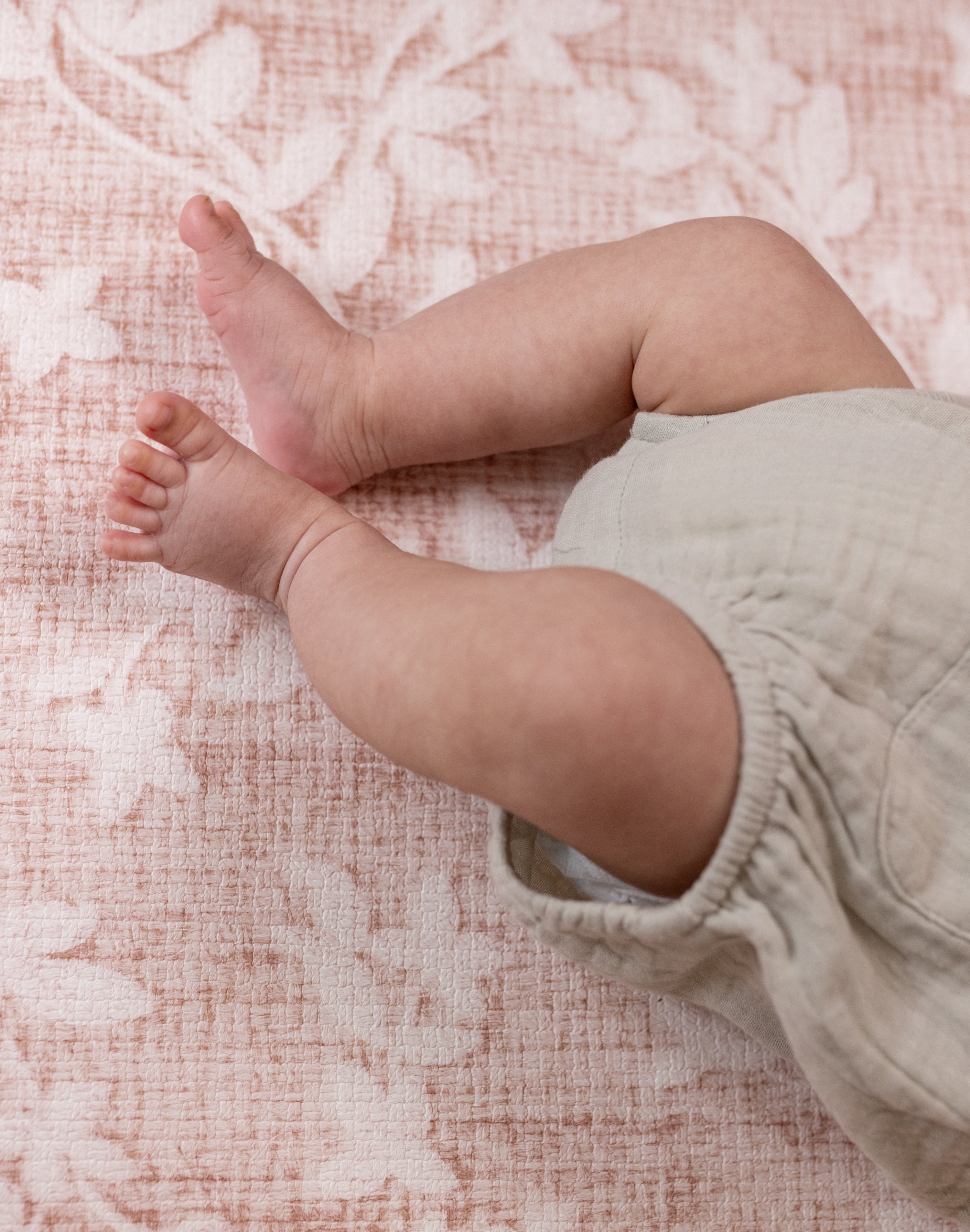 Baby's feet on the floral pink aster totter and tumble play mat