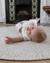 baby rolling on floor mat playrug that looks like a rug but a foam play mat in acorn design from morris & co collaboration with totter and tumble