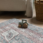 Close-up of Totter & Tumble mat with toy truck beside woven basket.