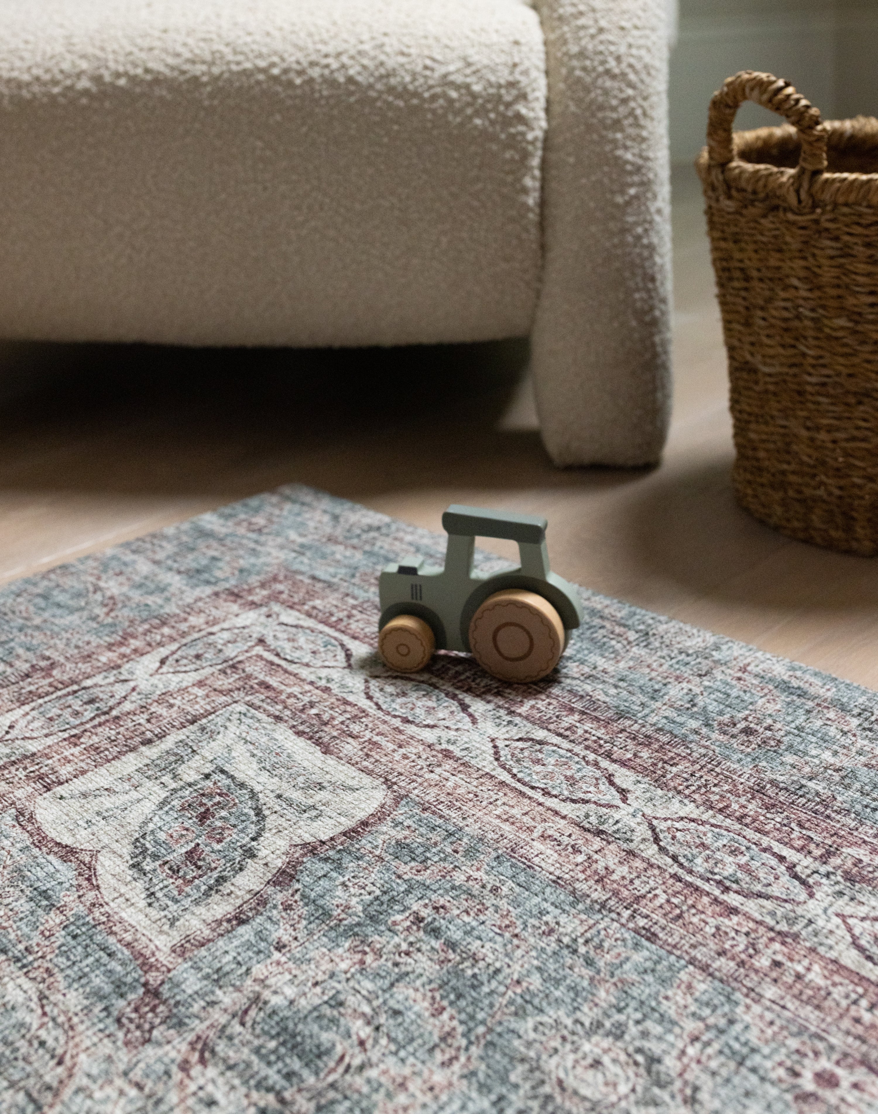 Close-up of Totter & Tumble mat with toy truck beside woven basket.