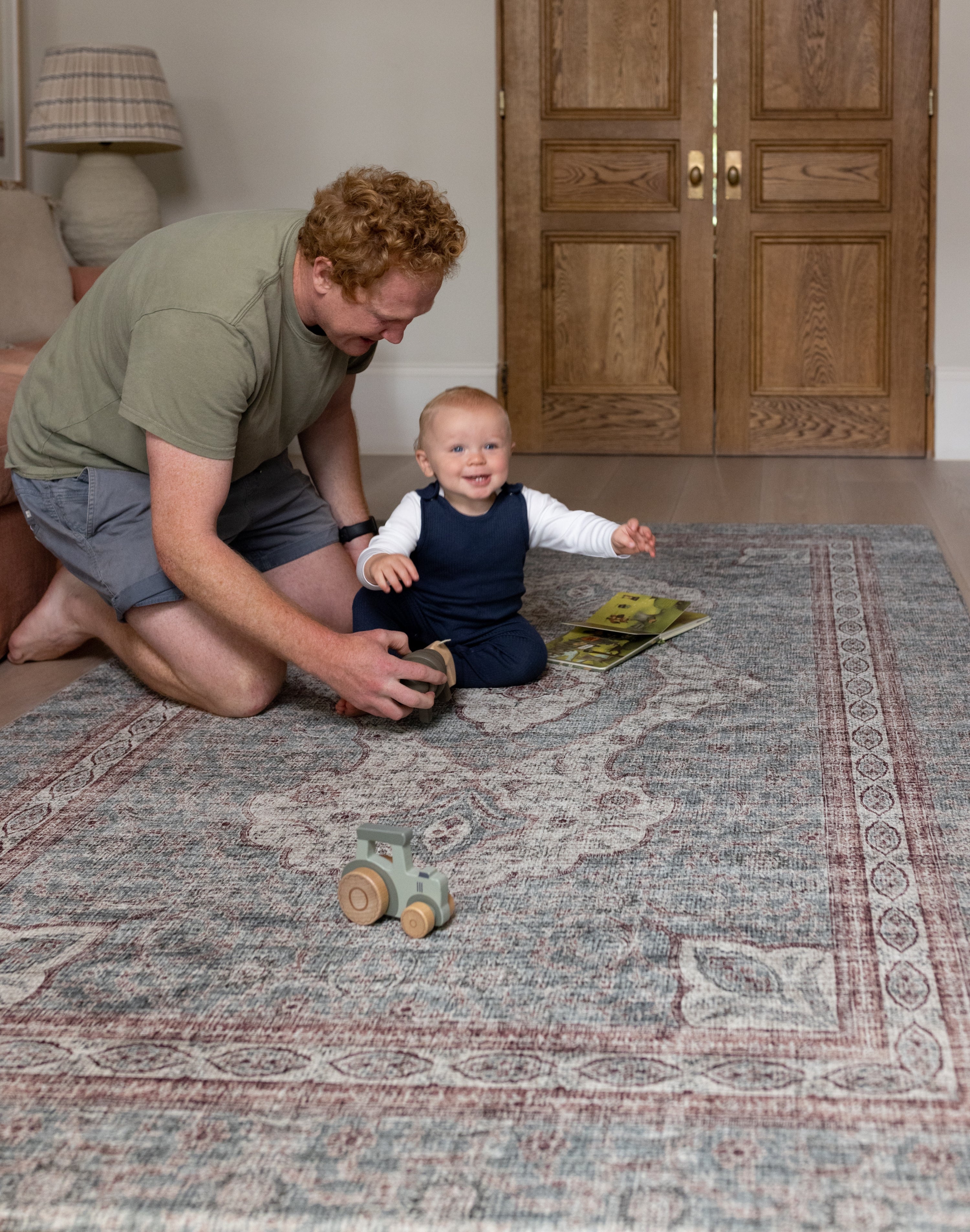 Dad and toddler playing together on Totter + Tumble padded play mat.
