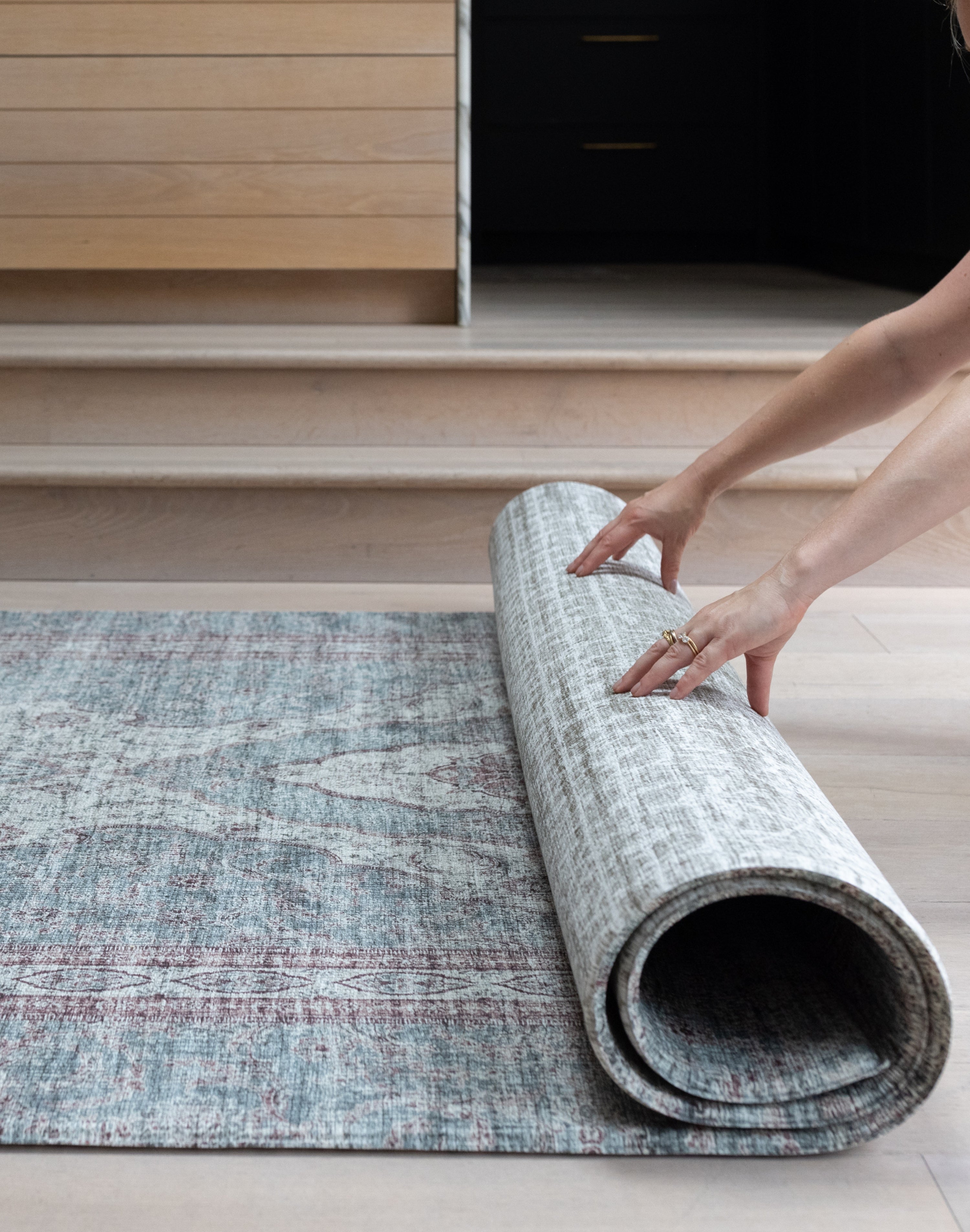 Rolling up a Totter & Tumble play mat to show flexible, easy to store design.