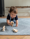 Little boy enjoys play time on the cushy play rug by Totter and Tumble with a monochrome grey and white rug design