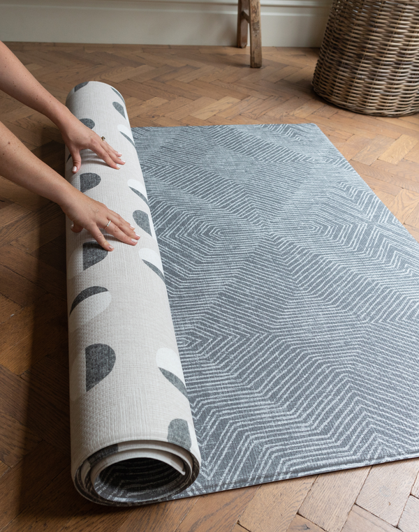 Hands unroll the astronomer and eclipse monochrome play mat with a memory foam design that can be enjoyed on both sides