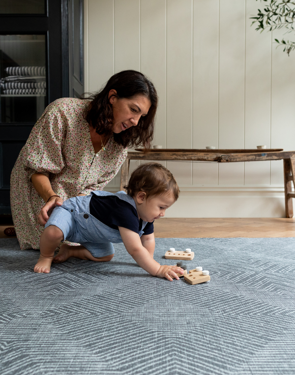 Lady and child enjoy floor time in comfort on grey play rug designed from birth with safe non toxic materials