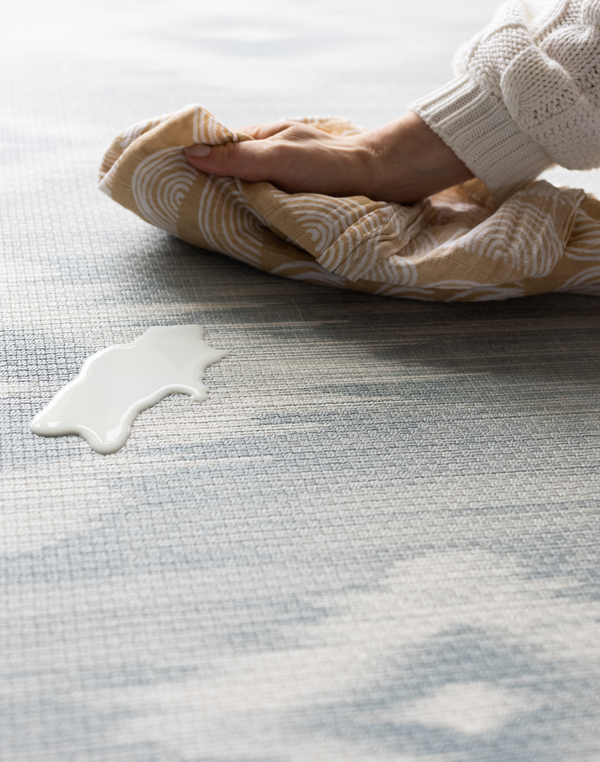 Cleaning milk spill on a Large round play mat by Totter and Tumble acts like a wipeable rug in the family home easy to clean spit up and spillages and looks stylish