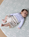 totter and tumble round size playmat with newborn baby relaxing on foam supportive and safe non toxic play rug in morris & co brer rabbit