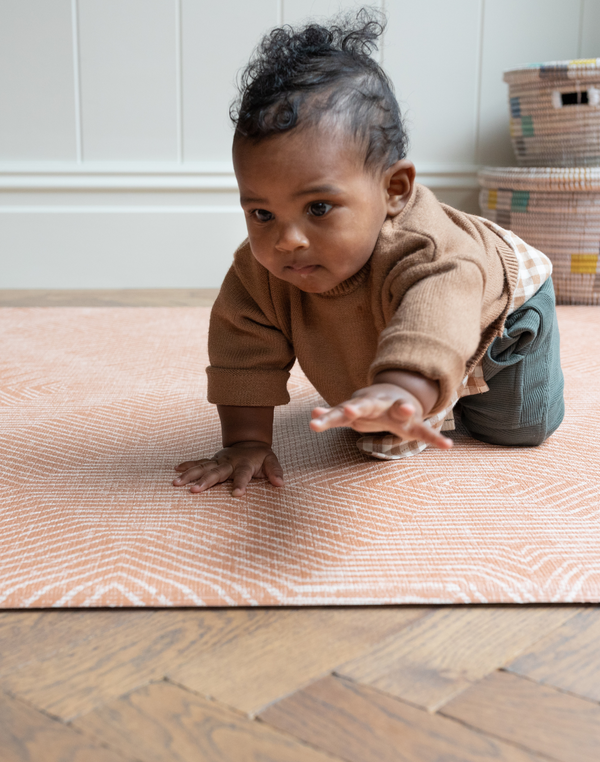 Baby crawls on soft play mat with. thick memory foam design that adds protection on the floor