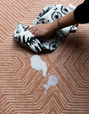 Wiping up spillage on anti slip playmat with contemporary terracotta design