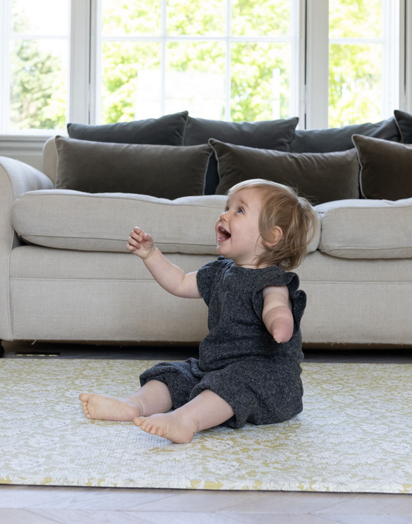 Adorable todder sitting on Chrysanthemum Morris & Co. playmat by luxury family brand Totter and Tumble
