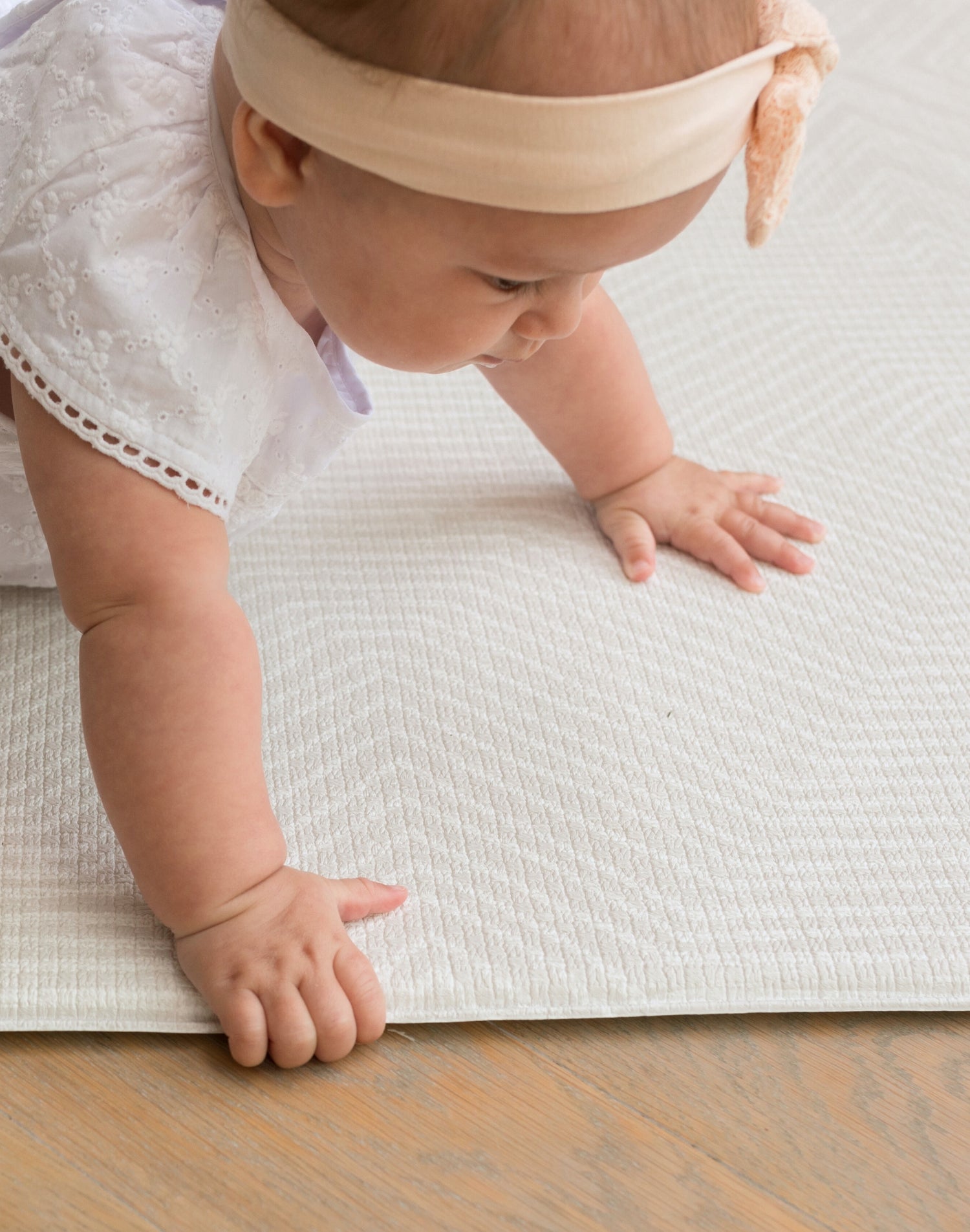 baby crawling on thick cushioned play mat