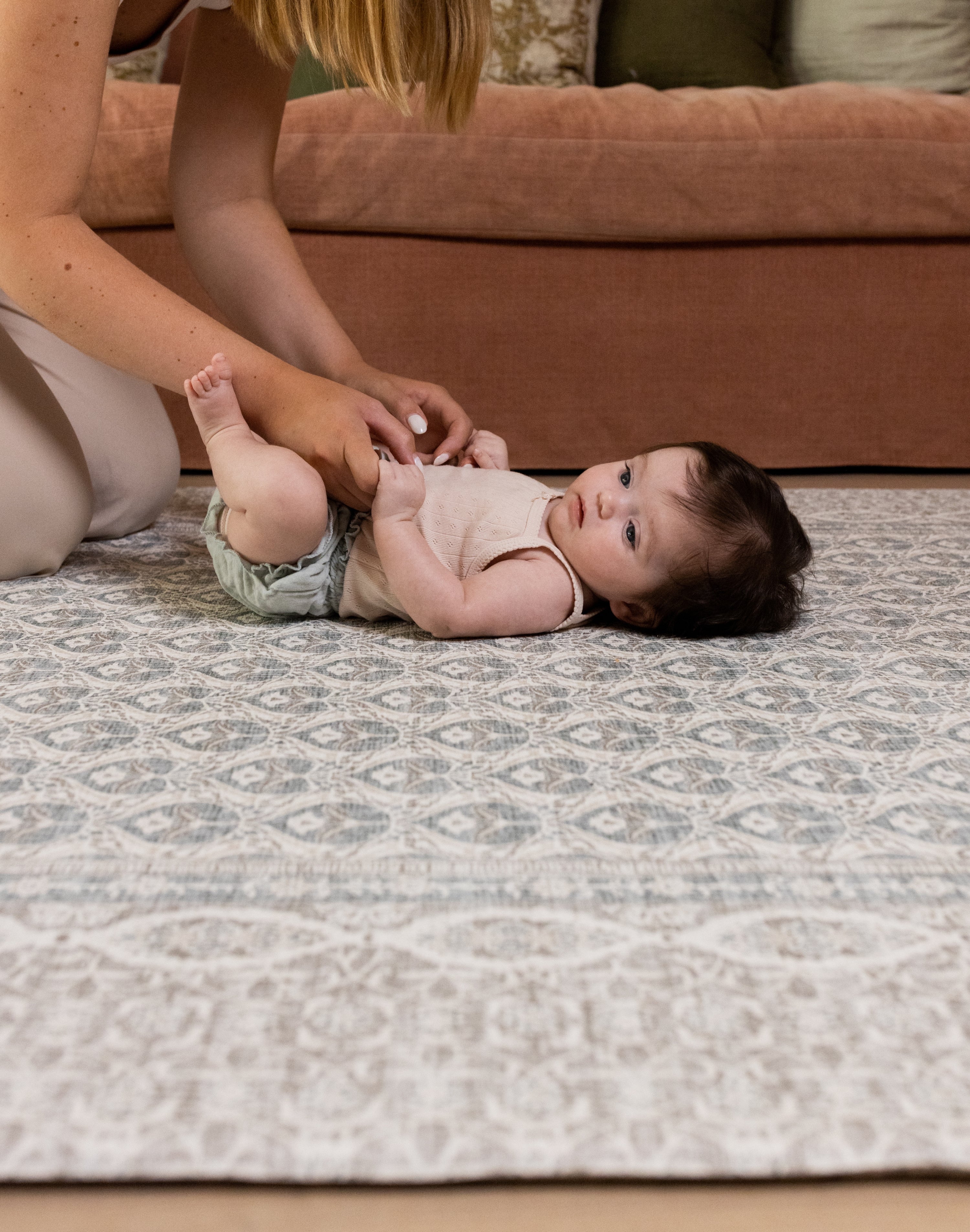 Baby lying on soft gray Totter & Tumble large play mat in stylish living room