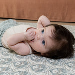Baby relaxing on soft grey baby mat in chic family room