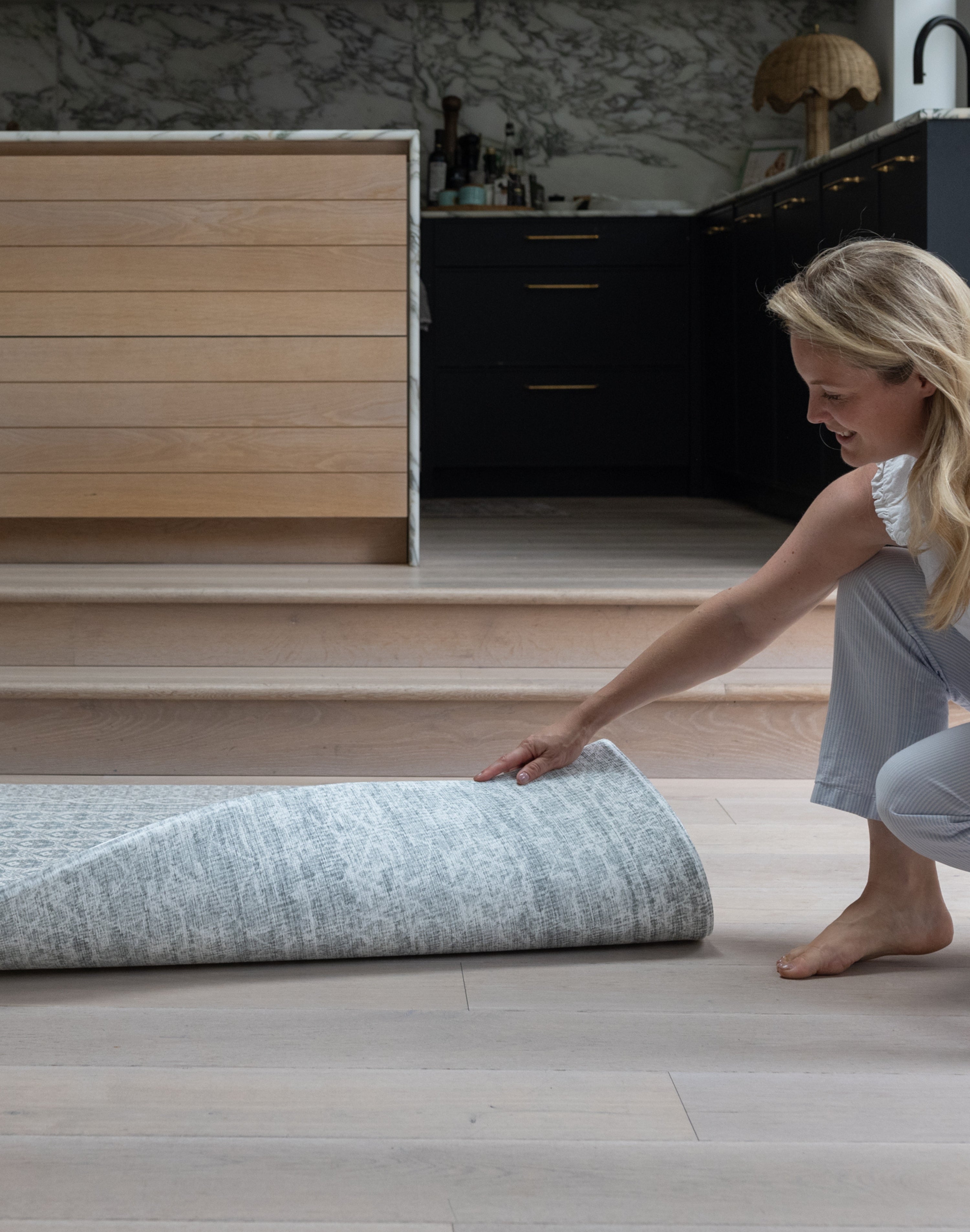 Unrolling a reversible play mat in a modern kitchen