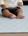 Little feet supported on scalloped foam mat that cushions to keep floor time comfortable