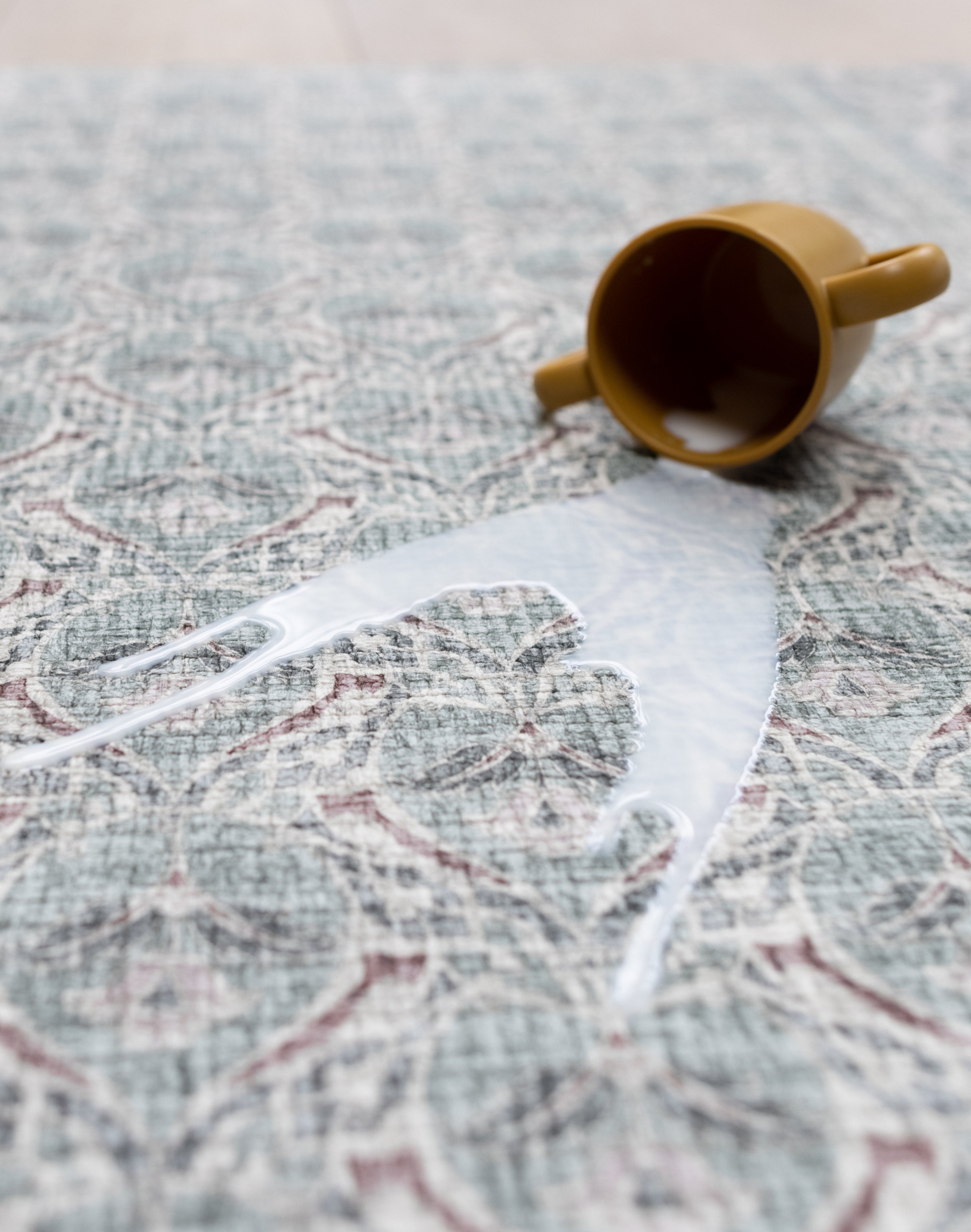 An easy to clean spill on a Totter and Tumble baby mat with a dusty pink and sage green pattern