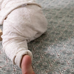 Crawling baby on a thick memory foam play mat from Totter + Tumble