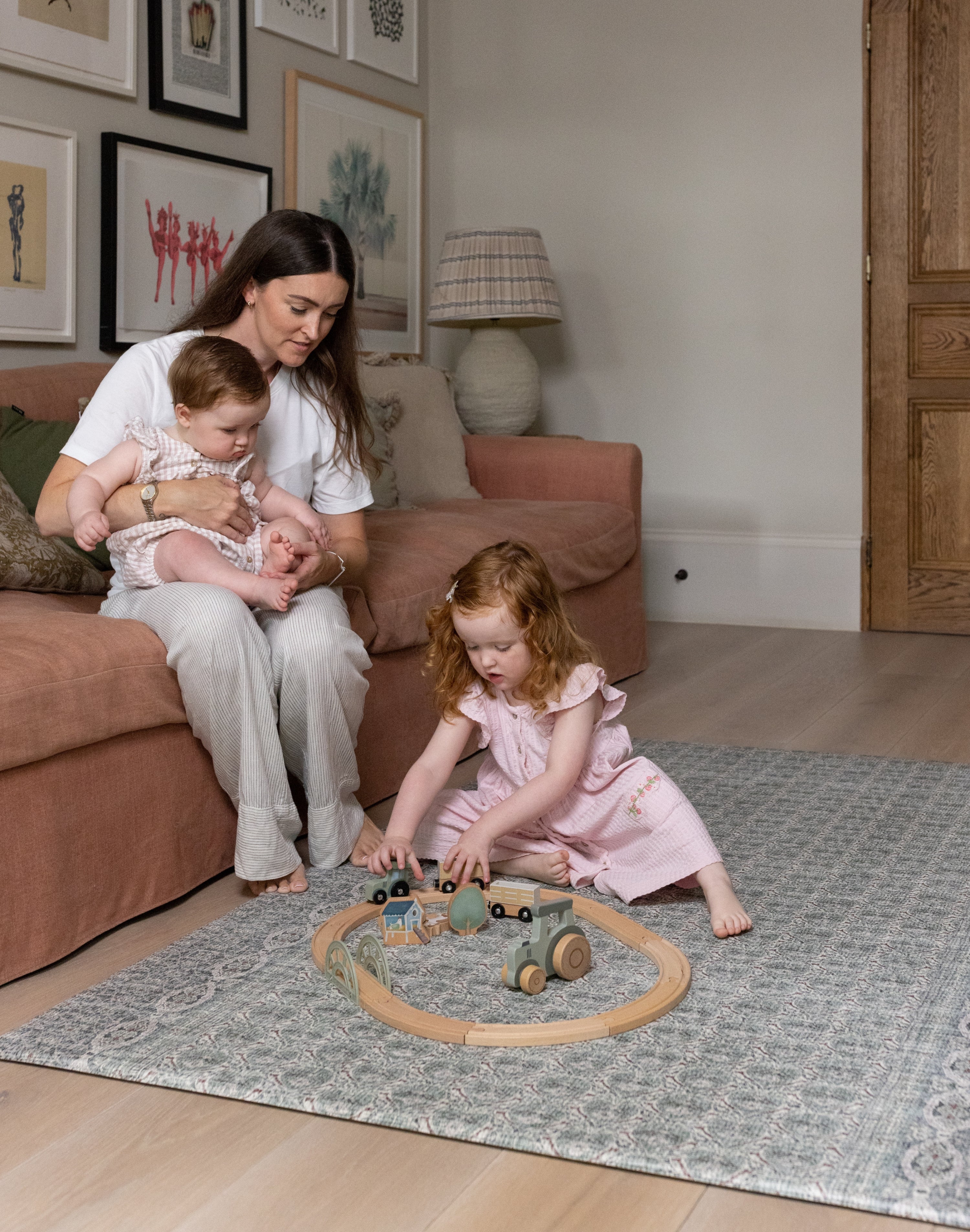 Family sitting together and playing on Totter + Tumble soft spruce play mat in a stylish living room