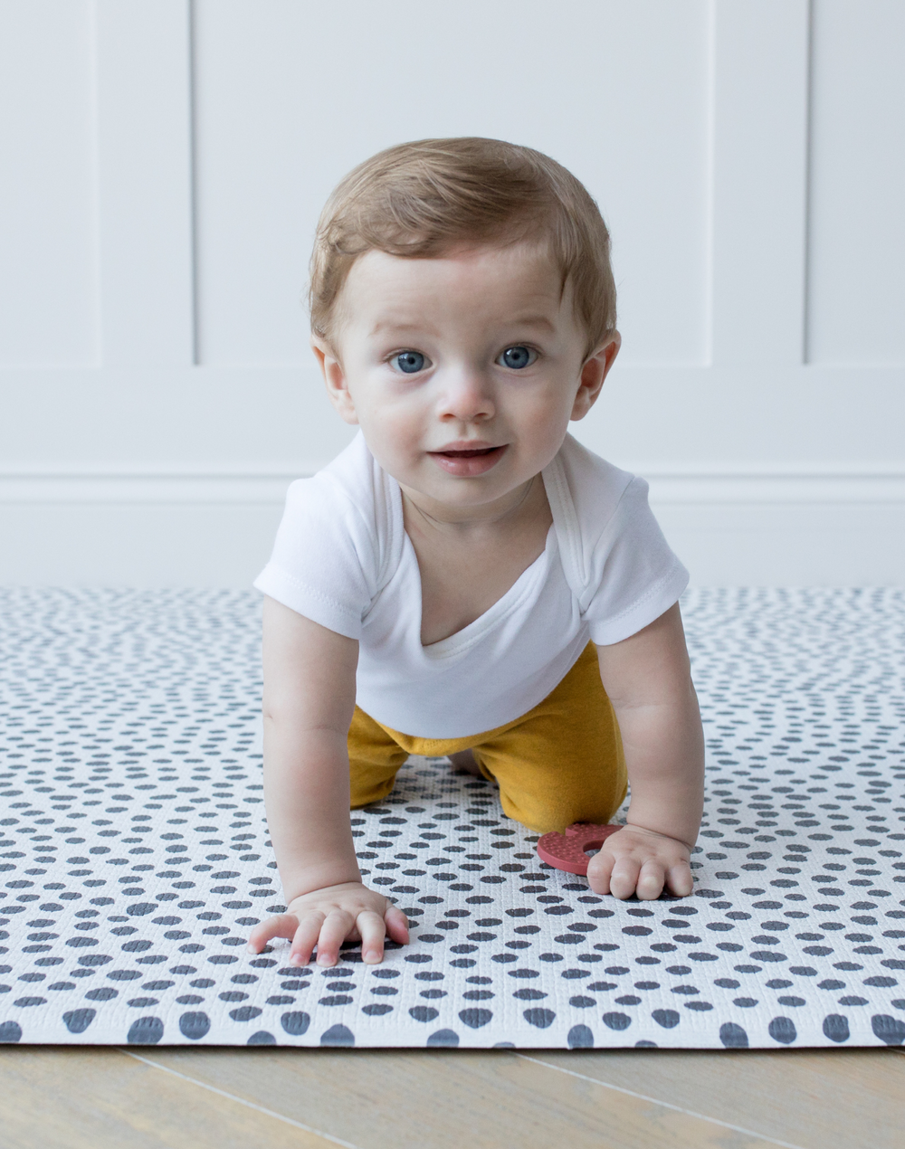 Baby is supported on a minimalist and sleek memory foam baby play mat that blends seamlessly with any decor