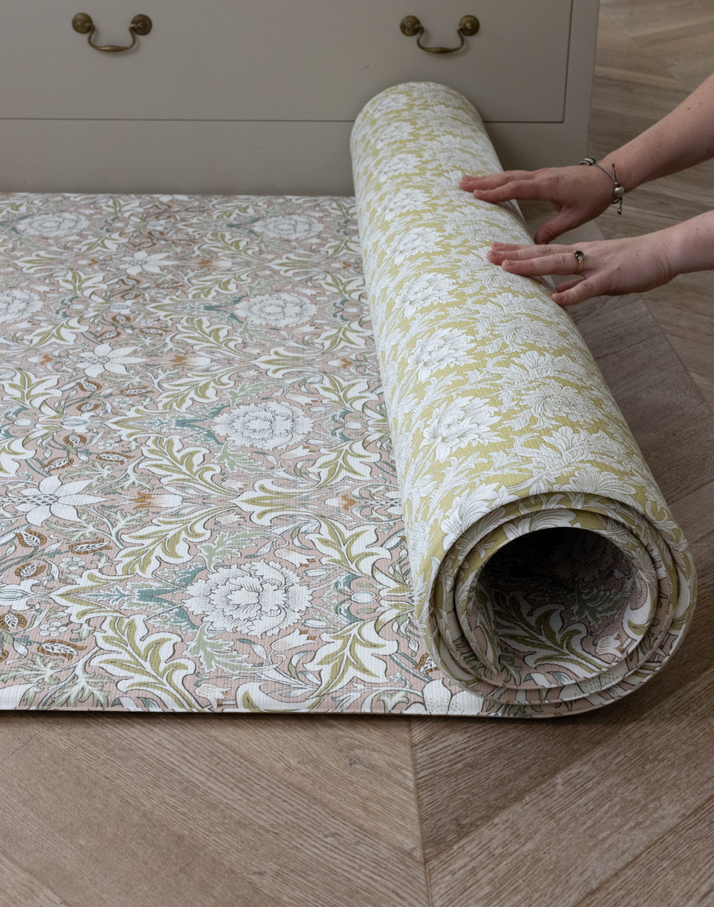 Unrolling double sided memory foam Totter and Tumble Severn play mat with Chrysanthemum design on the reverse easy to unroll and move around the home