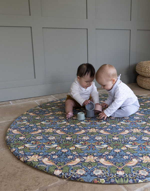 Adorable babies playing on round Totter and Tumble play mat with stacking cups enough space for fun play mats on the one-piece memory foam design