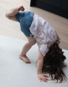 Little girl practices yoga on extra large yoga mat with modern chevron design