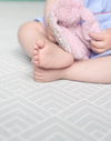 Baby sits unaided with the protection of a padded play mat